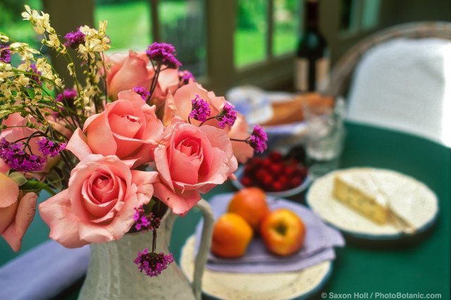 Bouquet of pink rose 'Tiffany' on sun porch with lunch table
