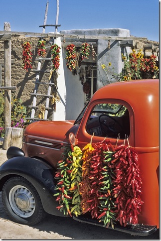 A red pickup truck draped with bright chile ristas makes a colorful composition in September at a fruit stand near the village of Velarde in northern New Mexico.