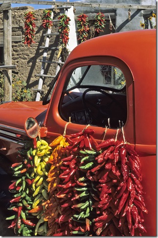 A red pickup truck draped with bright chile ristas makes a colorful composition in September at a fruit stand near the village of Velarde in northern New Mexico.