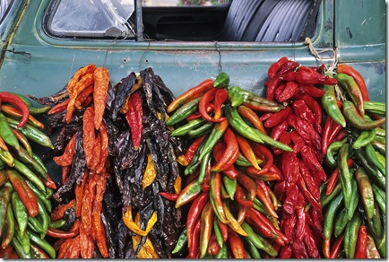 In September, strings of red, orange and green chile peppers hang from an old pickup truck at a fruit stand near the village of Velarde in northern New Mexico.