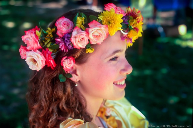 Girl as May fair princess with flower garland of roses in her hair